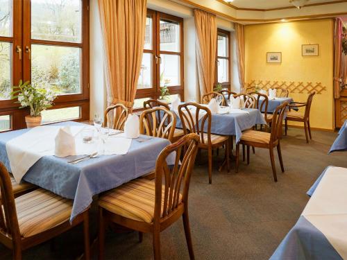 a restaurant with tables and chairs and windows at Hotel Gasthof zum Biber in Motten