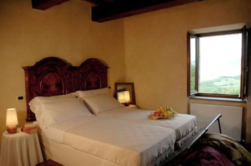a bedroom with a large white bed with a window at Agriturismo Monastero Di San Biagio in Nocera Umbra