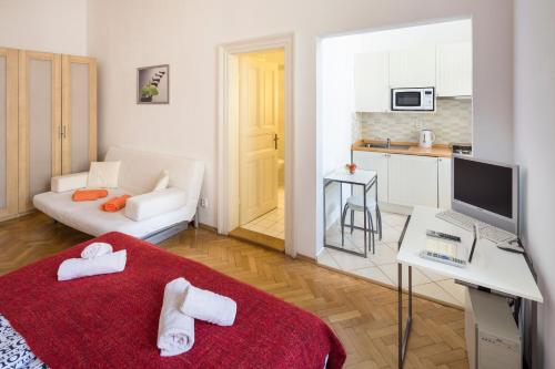 a small apartment with a red bed and a kitchen at Dušní Apartments in Prague