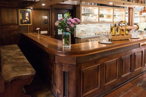 a large wooden bar with a vase of flowers on it at Landgasthof zum Erdinger Weissbräu in Rosenheim