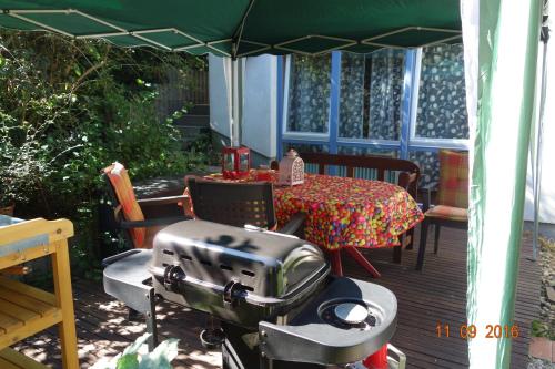 a patio with a table and a grill on a deck at Haus Weschke in Hofheim am Taunus