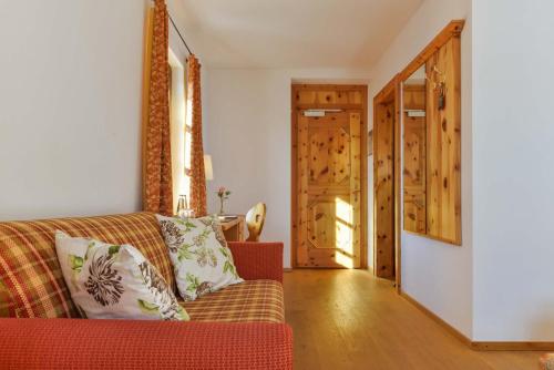 a living room with a red couch and wooden floors at Landgasthof zum Erdinger Weissbräu in Rosenheim