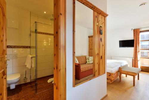 a bathroom with a shower and a bed in a room at Landgasthof zum Erdinger Weissbräu in Rosenheim