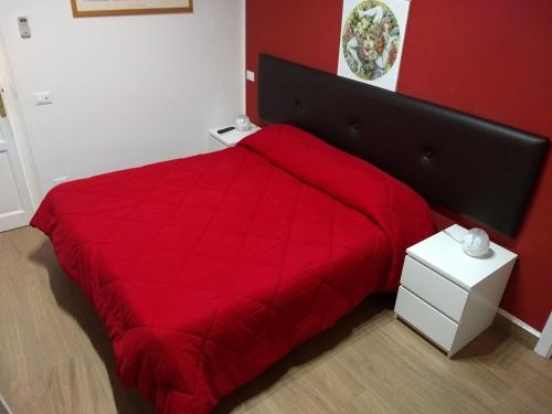 a red bed with a red comforter in a bedroom at Vado Al Massimo in Palermo