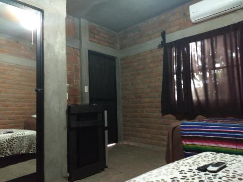 a room with two beds and a window and a mirror at Posada Don Jose in El Fuerte