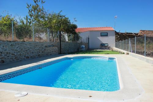 a swimming pool in the backyard of a house at Curral D Avó Turismo Rural & SPA in Caçarelhos