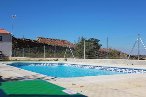 a swimming pool with a fence around it at Curral D Avó Turismo Rural & SPA in Caçarelhos