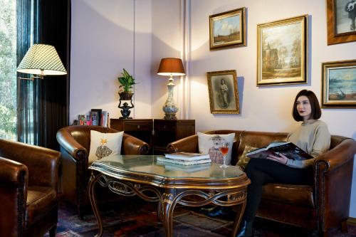 a woman sitting in a living room with a table at Townhouse Boutique Hotel in Zürich