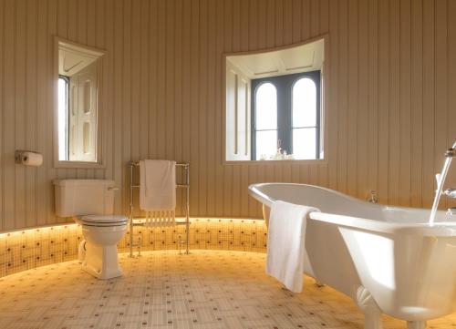 a bathroom with a tub and a toilet at Kilkea Castle in Kilkea