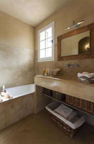 une salle de bain avec un lavabo, une baignoire et un miroir dans l'établissement Maison de charme Pampelonne Saint Tropez, à Saint-Tropez