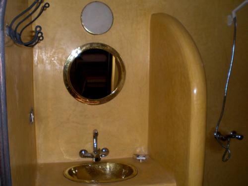 La salle de bains est pourvue d'un lavabo en or et d'un miroir. dans l'établissement La Kasbah d'Ouzoud, à Ouzoud