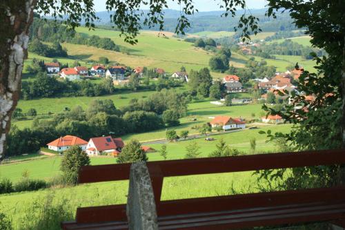 a view of a green valley from a wooden bench at Hotel Gasthof zum Biber in Motten
