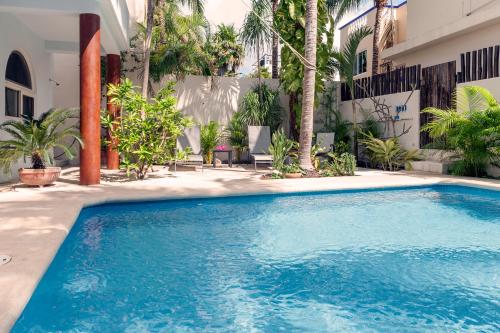 a swimming pool in front of a building at Casa Sonoma - Charming Condos Minutes from Beach & Reef in Puerto Morelos