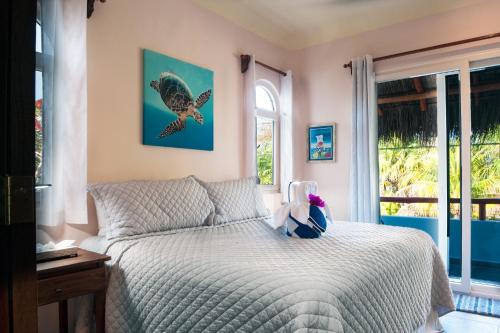 a bedroom with a bed with a bird picture on the wall at Casa Sonoma in Puerto Morelos