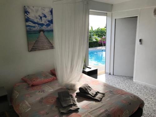 a bedroom with a bed and a view of a pool at L'Orchidée Bleue in Sainte-Anne