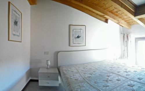 トレモージネ・スル・ガルダにあるAttico Florian Vesio by Gardadomusmeaの白いベッドルーム(ベッド1台、窓付)