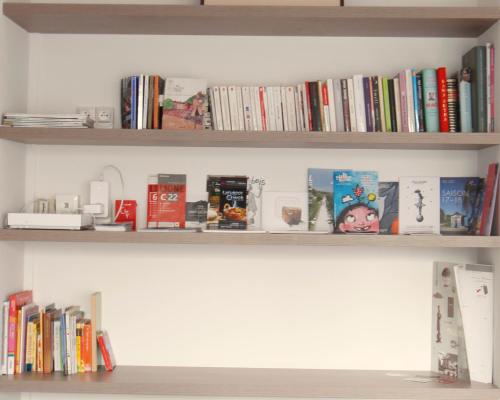 a book shelf with books and other books at Mon Appart A GERLAND II in Lyon
