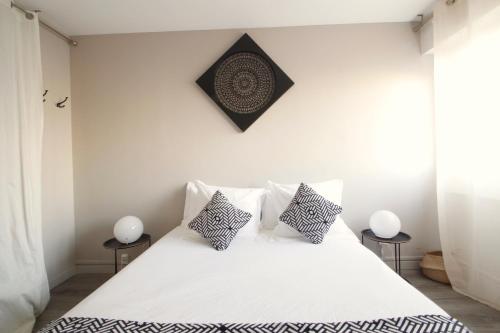 a bedroom with a white bed with two side tables at Mon Appart A GERLAND II in Lyon