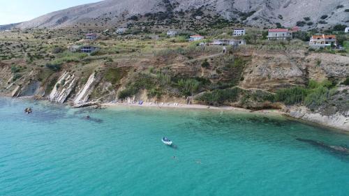 eine Luftansicht auf einen Strand mit Menschen im Wasser in der Unterkunft Apartmani Vesna in Pag