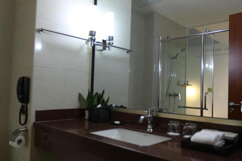 a bathroom with a sink and a large mirror at Dayi Yihao hotel in Xiamen