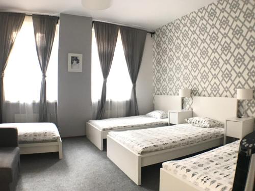 ヴロツワフにあるCityAparts - Rynek View 2 Bedrooms Private Apartment - FVのベッドルーム(ベッド3台、ソファ付)