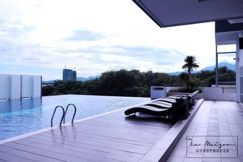 a swimming pool with a row of chairs next to the water at Le Maison GuestHouse @ Majestic Imperial in Ipoh