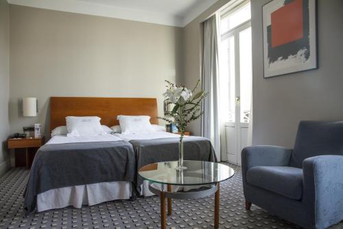 a hotel room with a bed and a table and a chair at Gran Hotel Albacete in Albacete