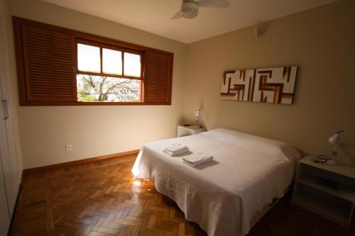 ein Schlafzimmer mit einem weißen Bett und einem Fenster in der Unterkunft Casa Antunes in Diamantina