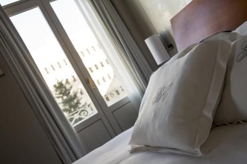 a white pillow sitting on a bed with a window at Gran Hotel Albacete in Albacete