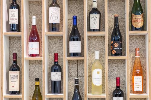 un montón de botellas de vino en una pared en A de Loló Alojamiento con encanto, en Muxía
