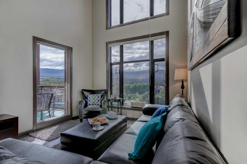 a living room with a couch and large windows at Playa Del Sol Resort - Vacation Rentals in Kelowna