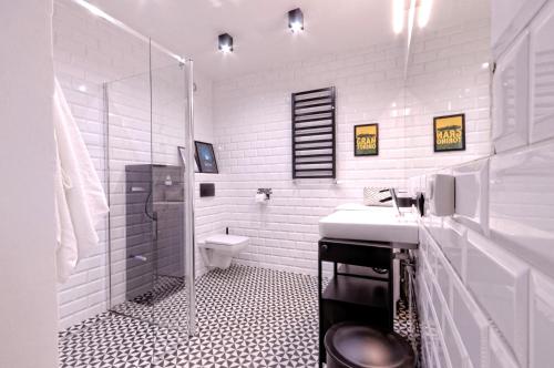 La salle de bains blanche est pourvue d'un lavabo et de toilettes. dans l'établissement Industrialny Kwadrat, à Złotów