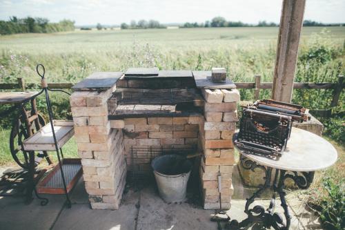 a brick oven with a table next to a field at Clopton Courtyard Cambridge in Cambridge