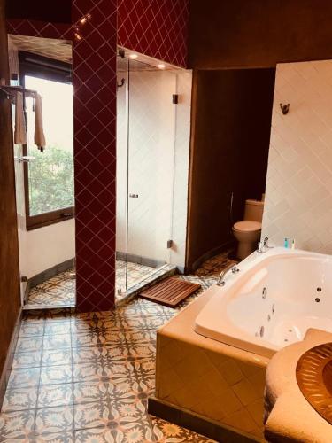 a large bathroom with a tub and a shower at Hacienda Ucazanaztacua in Pátzcuaro