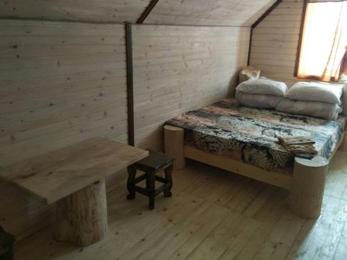 a room with a bed and a table in a cabin at Готель Людмила in Synevyr