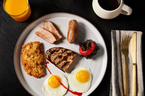 een bord ontbijtproducten met eieren, worst en toast bij San Francisco Proper Hotel, a Member of Design Hotels in San Francisco