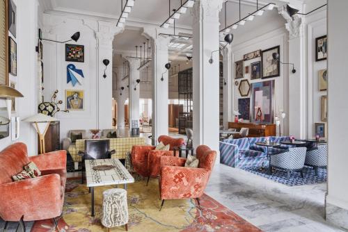 a lobby with red chairs and tables in a building at San Francisco Proper Hotel, a Member of Design Hotels in San Francisco