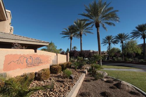 a sign for the entrance to a resort with palm trees at The Cliffs at Peace Canyon in Las Vegas
