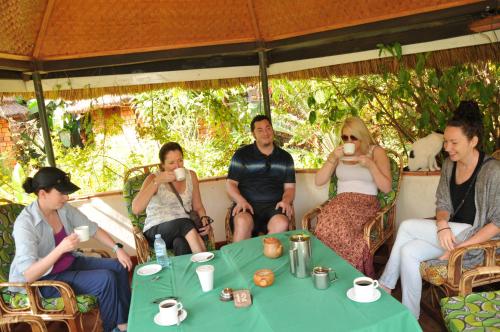 a group of people sitting around a table at New Court View Hotel in Masindi