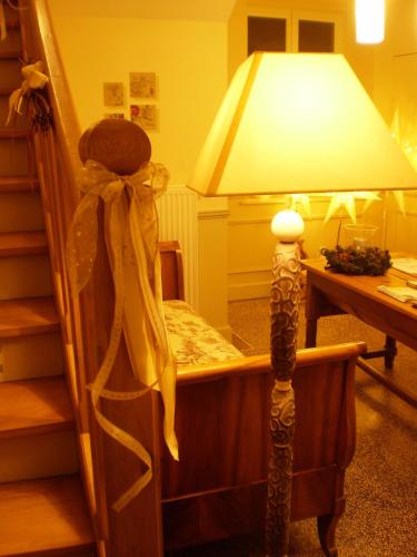 a room with a table with a lamp and a chair at Chambres d'Hôtes le Clos des Lesses in Fresse-sur-Moselle