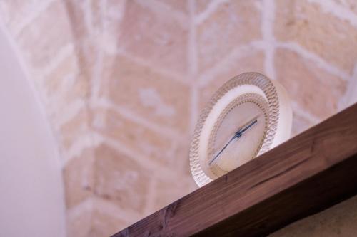 a white clock sitting on top of a shelf at Apulia '800 in San Pietro Vernotico