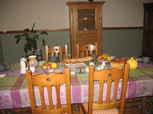 una mesa de comedor con una mesa con comida. en Chambres d'hôtes Le Chardon Fleuri, en Teuillac