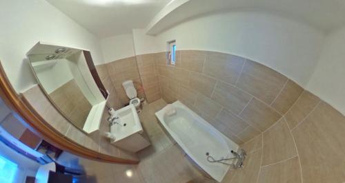 a bathroom with a tub and a sink and a mirror at Csikos Apartment in Cluj-Napoca