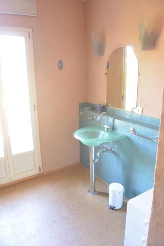 une salle de bain avec un lavabo vert et un miroir dans l'établissement Bastide des ribias, à Aups