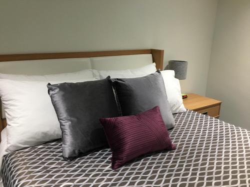 a bed with a bunch of pillows on it at University of Alberta - PLH Accommodation in Edmonton