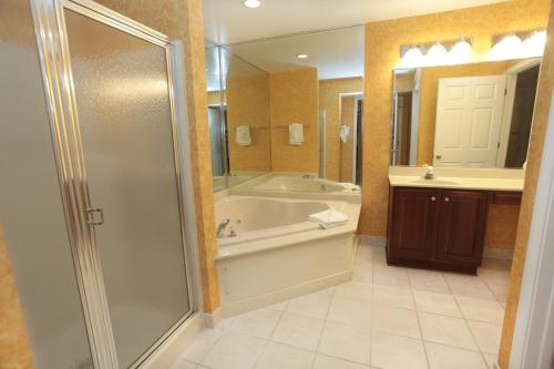 y baño con ducha, bañera y lavamanos. en Vacation Village at Williamsburg en Williamsburg