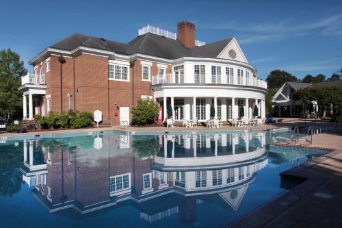 a large brick house with a reflection in the water at Vacation Village at Williamsburg in Williamsburg