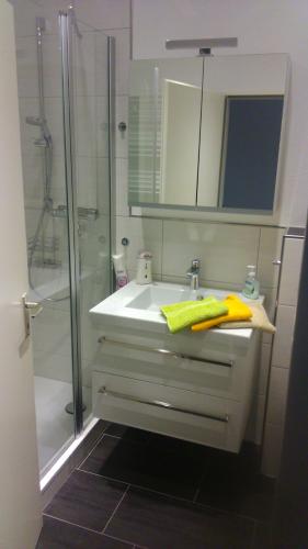 een witte badkamer met een wastafel en een douche bij Ferienappartement Feldstrasse in Winterberg