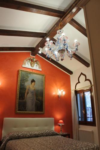 a bedroom with a painting of a woman on the wall at Casa Torretta in Venice