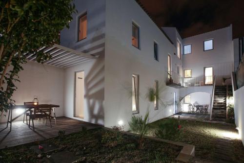 a large white building with a table on a patio at Place Of Moments Urban-Suites in Ponta Delgada